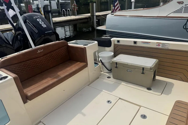 Slide: The Image of 2023 Scout 400 LXF boat interior with brown seating and Yeti cooler. - 9