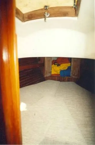 Slide: The Image of 1965 Pearson Vanguard sailboat interior cabin with cozy bedding and wooden accents. - 14