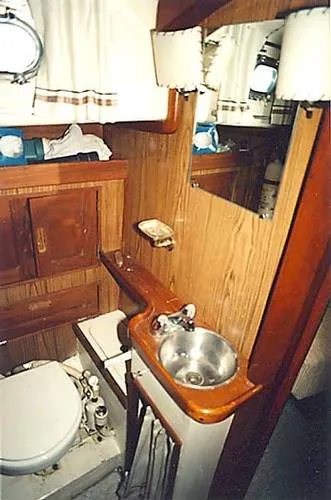Slide: The Image of 1965 Pearson Vanguard yacht bathroom with wooden cabinetry and stainless steel sink. - 15