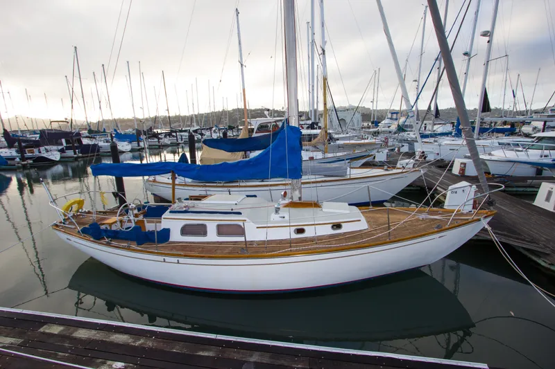 Slide: The Image of 1965 Pearson Vanguard sailboat docked in a marina, featuring classic design and wooden deck. - 2