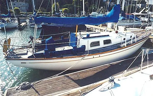 Slide: The Image of 1965 Pearson Vanguard sailboat docked at a marina, featuring a blue cover and classic design. - 3