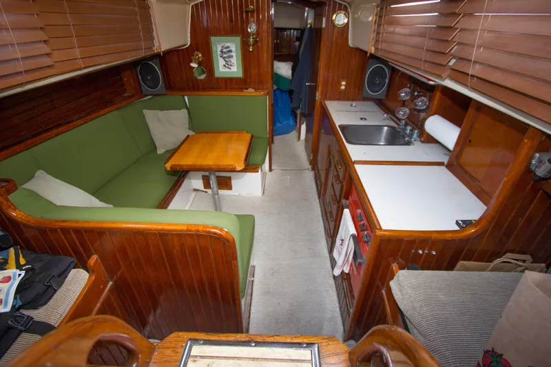 Slide: The Image of Interior of a 1965 Pearson Vanguard sailboat with wooden paneling and green seating. - 4