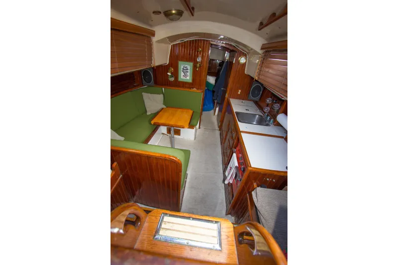 Slide: The Image of Interior of a 1965 Pearson Vanguard sailboat with green seating and wooden cabinetry. - 5