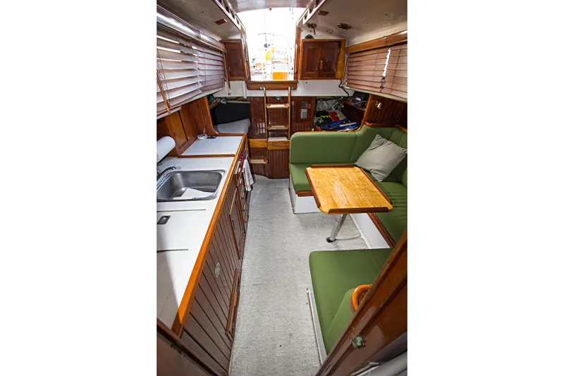 Slide: The Image of Interior of a 1965 Pearson Vanguard sailboat with green seating and wooden cabinetry. - 7