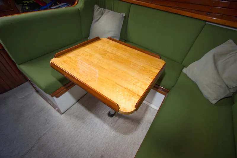 Slide: The Image of Interior of 1965 Pearson Vanguard sailboat with green seating and wooden table. - 9