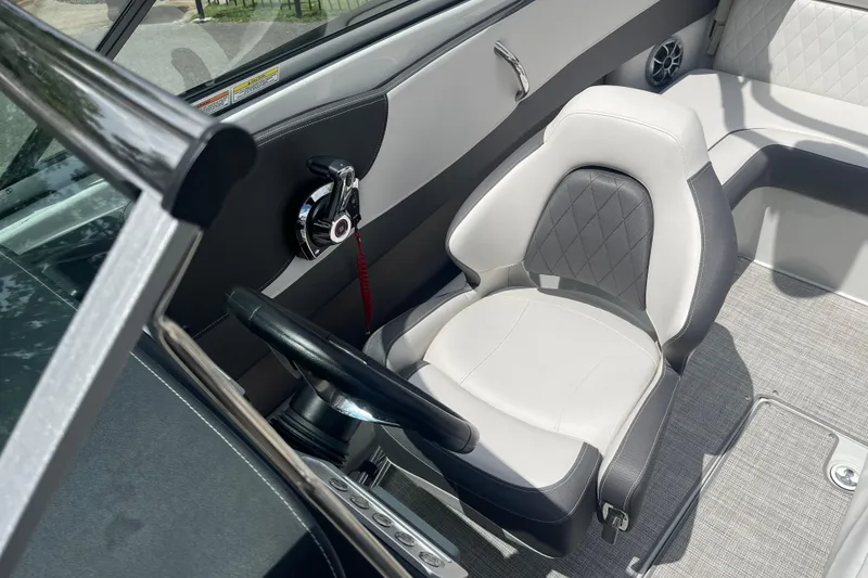 Slide: The Image of 2024 Crownline 240 SS boat interior with steering wheel and cushioned seat. - 3