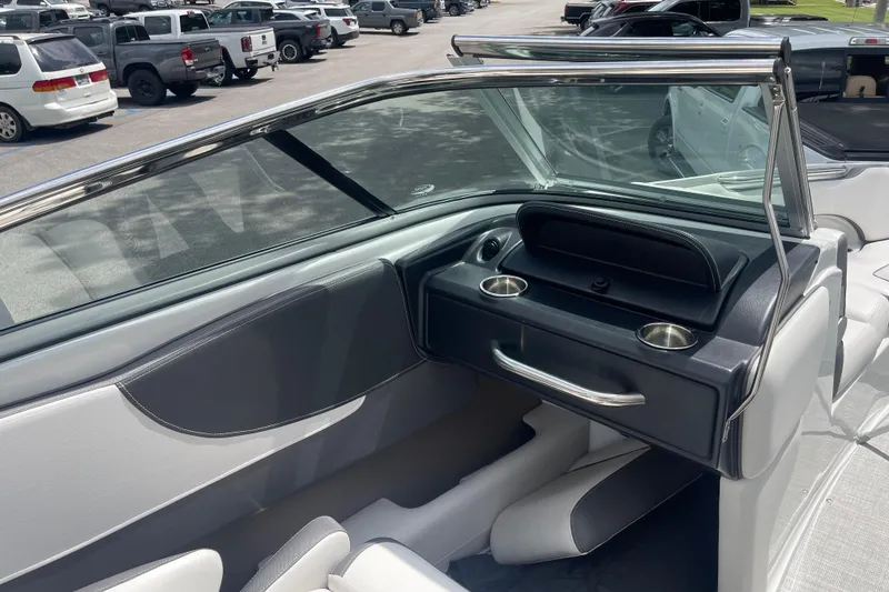 Slide: The Image of 2024 Crownline 240 SS boat interior with sleek dashboard and cup holders. - 5