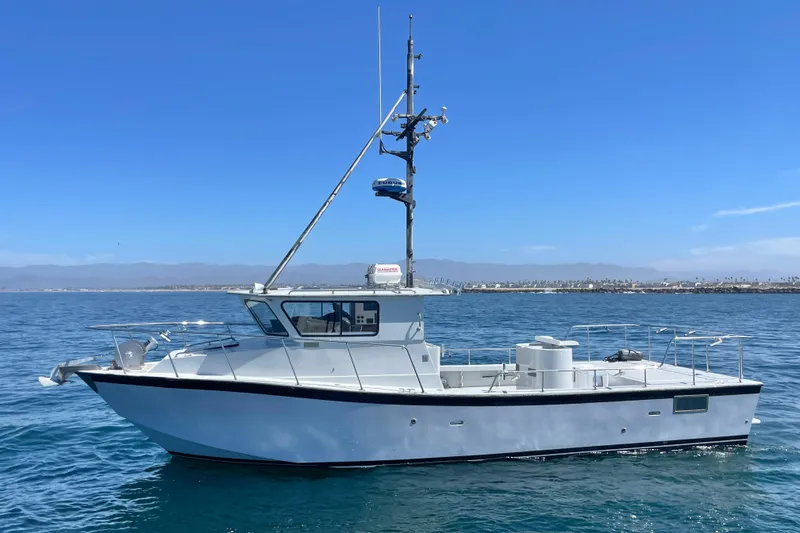 The Image of Custom NUWAVE 36 boat from 1990 on calm ocean waters under clear blue sky. - 0