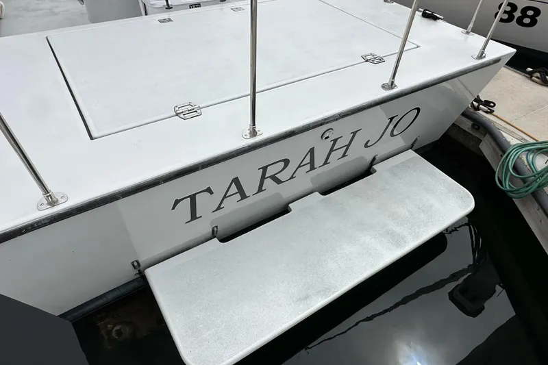 Slide: The Image of Custom NUWAVE 36 boat named "TARAH JO" docked, featuring a swim platform. - 12