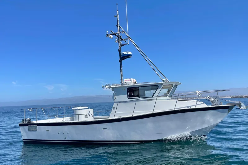 Slide: The Image of Custom NUWAVE 36 boat from 1990 on open water under clear blue sky. - 2