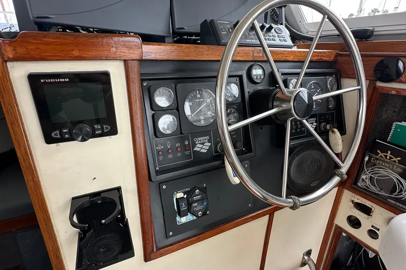 Slide: The Image of Boat helm of Custom NUWAVE 36, 1990 model, featuring steering wheel and navigation instruments. - 24