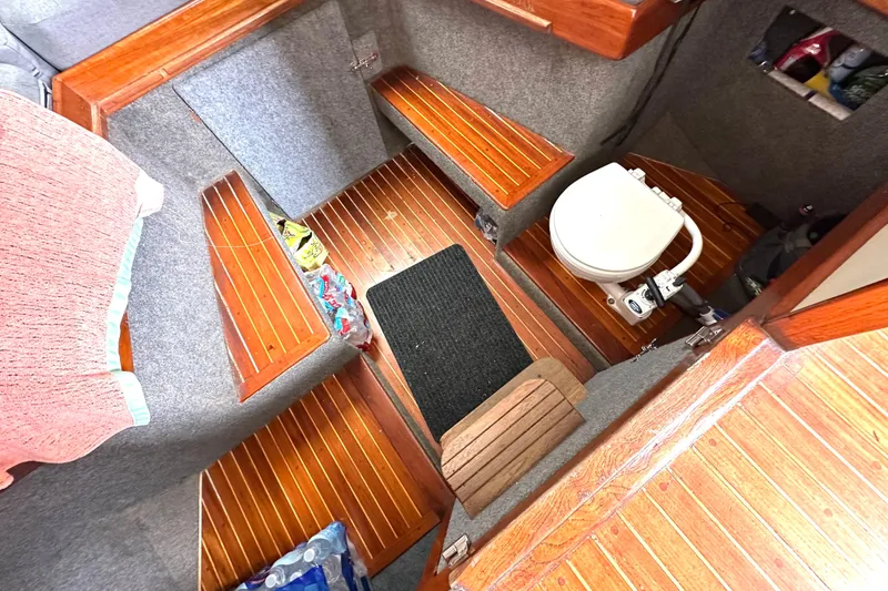 Slide: The Image of Compact boat interior with wooden flooring, toilet, and storage, Custom NUWAVE 36, 1990 model. - 25