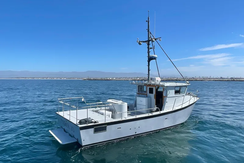 Slide: The Image of Custom NUWAVE 36 boat from 1990 on calm ocean waters under clear blue sky. - 5