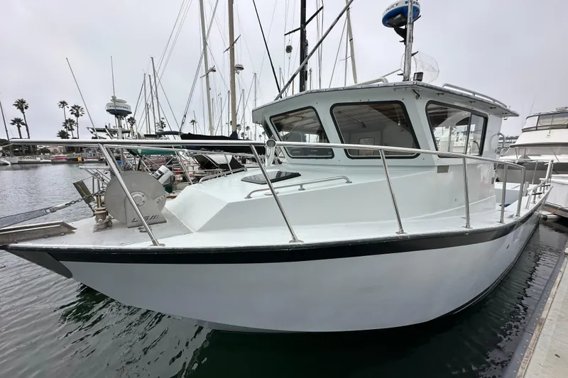 Slide: The Image of Custom NUWAVE 36 boat, 1990 model, docked in marina with sailboats and palm trees. - 8