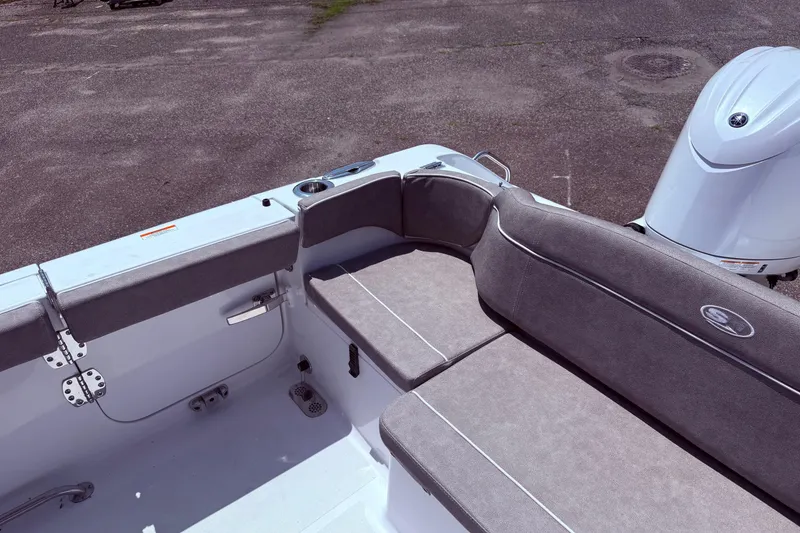 Slide: The Image of 2026 Sea Hunt Ultra 265 SE boat interior with cushioned seating and motor. - 14
