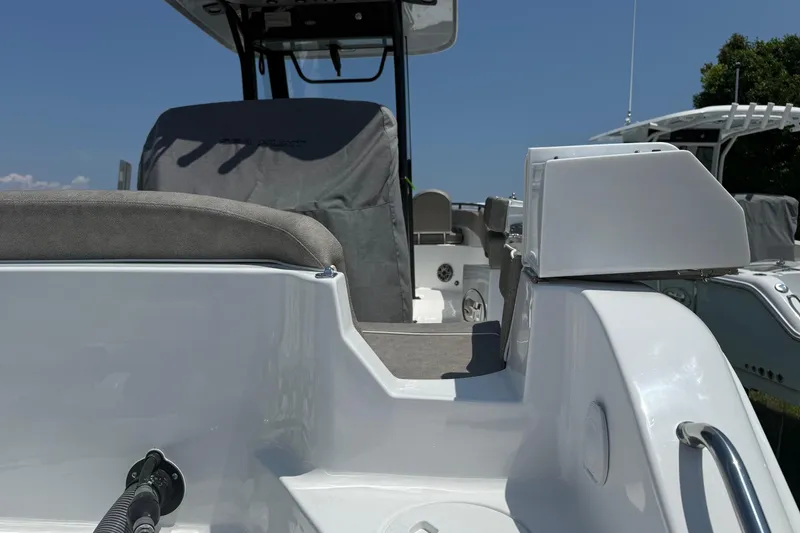 Slide: The Image of 2026 Sea Hunt Ultra 265 SE boat interior with seating and console, under clear blue sky. - 18