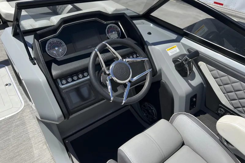 Slide: The Image of 2022 Godfrey AquaPatio 255 SBW boat dashboard with steering wheel and controls. - 3