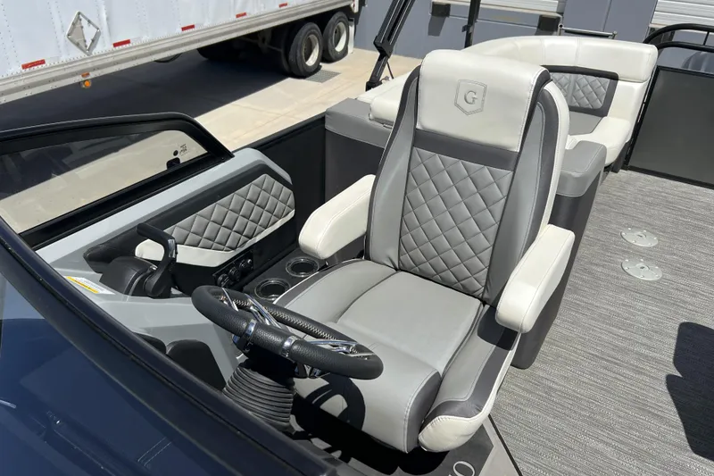 Slide: The Image of Captain's seat of 2022 Godfrey AquaPatio 255 SBW boat, featuring luxurious gray upholstery. - 7