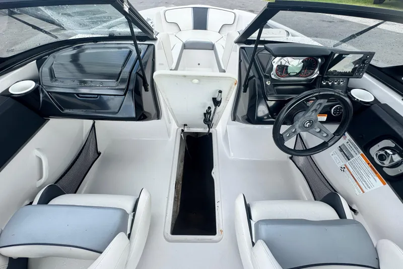Slide: The Image of Interior of a 2018 Scarab 195 G boat, featuring steering wheel and seating. - 14