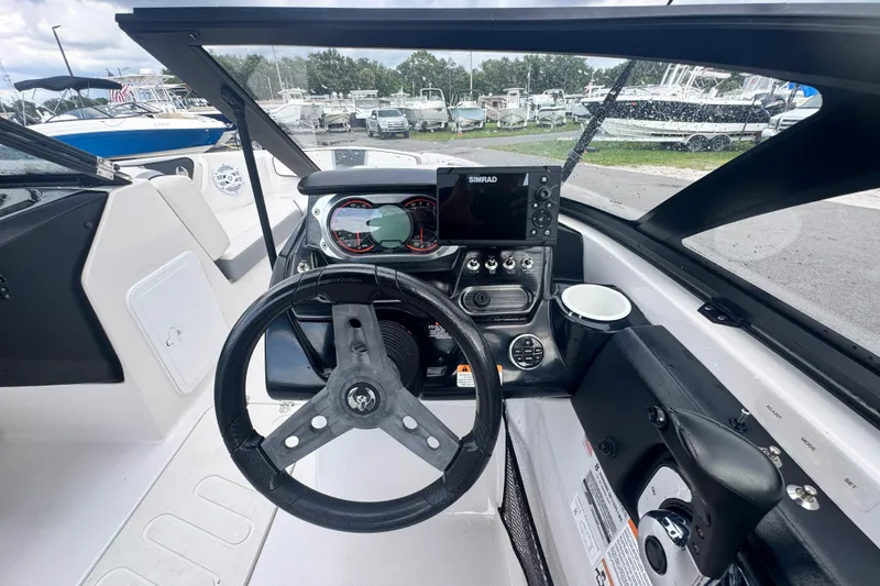 Slide: The Image of Interior view of 2018 Scarab 195 G boat cockpit with steering wheel and navigation system. - 15