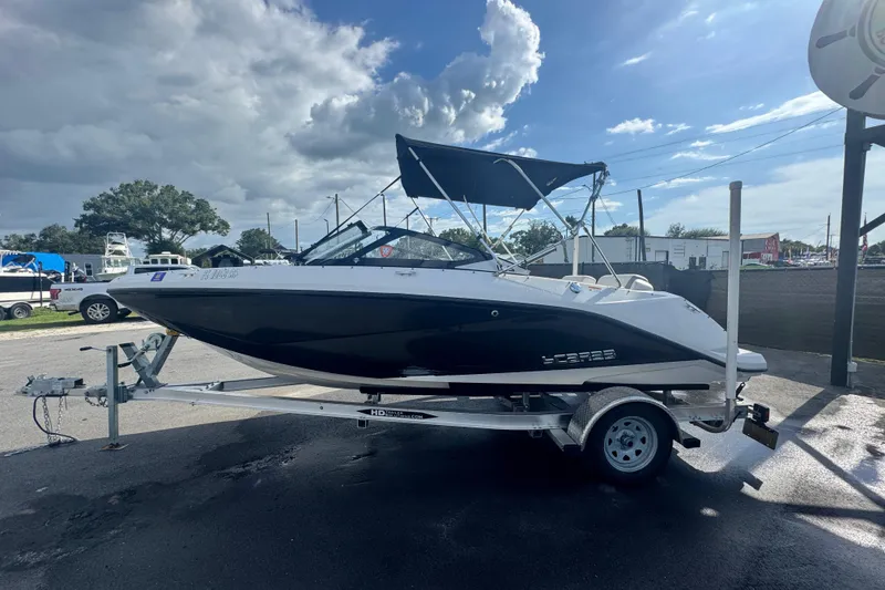 Slide: The Image of 2018 Scarab 195 G boat on trailer, parked outdoors under cloudy sky. - 6