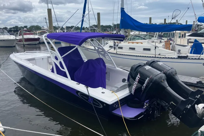 The Image of 2014 Concept 30 Cuddy boat with purple canopy and twin Mercury engines docked at marina. - 0