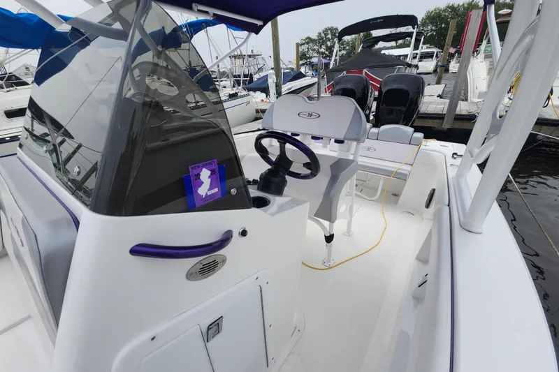 Slide: The Image of 2014 Concept 30 Cuddy boat interior with steering wheel and seating at marina. - 18