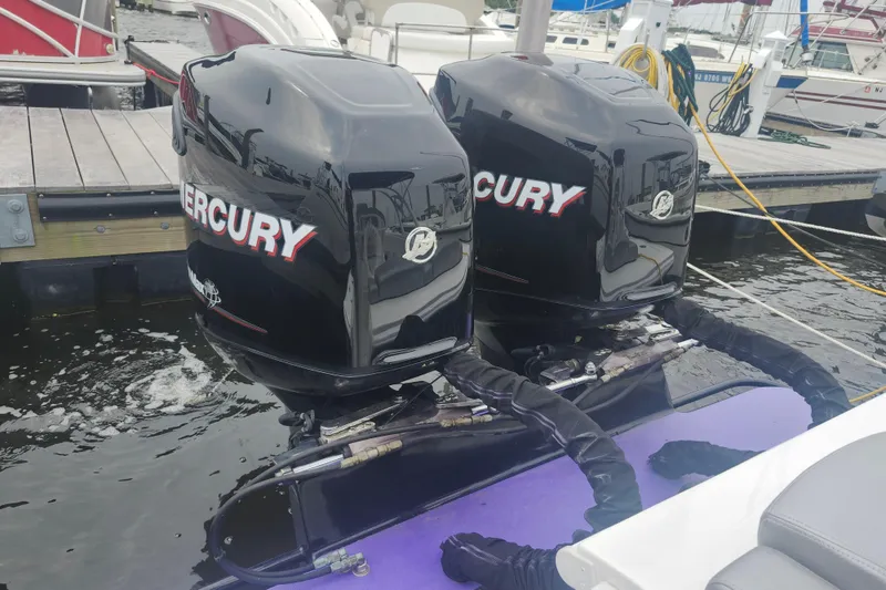 Slide: The Image of Twin Mercury outboard engines on a 2014 Concept 30 Cuddy boat at a marina. - 30