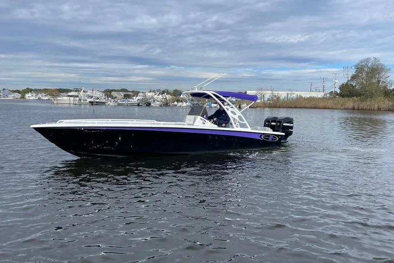 Slide: The Image of 2014 Concept 30 Cuddy boat on calm water, featuring sleek design and dual Mercury engines. - 48