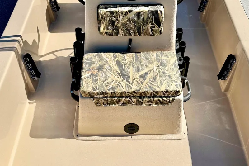 Slide: The Image of 2026 Carolina Skiff E18 JVX CC boat interior with camo-patterned seating and rod holders. - 13