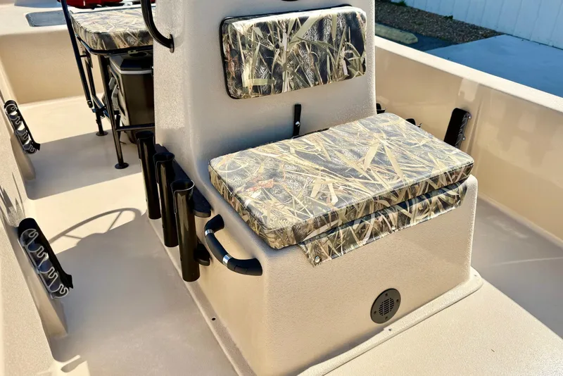 Slide: The Image of 2026 Carolina Skiff E18 JVX CC boat interior with camo-patterned seating and rod holders. - 14