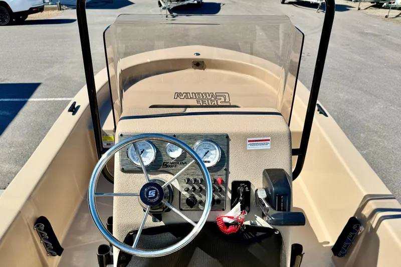 Slide: The Image of 2026 Carolina Skiff E18 JVX CC boat dashboard with steering wheel and gauges. - 3