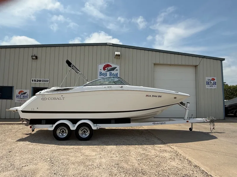 Slide: The Image of 2014 Cobalt 24SD boat on trailer outside Boji Boat dealership. - 0