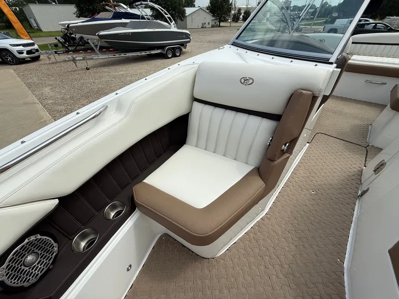 Slide: The Image of 2014 Cobalt 24SD boat interior with white and brown seating, cup holders, and speaker. - 14