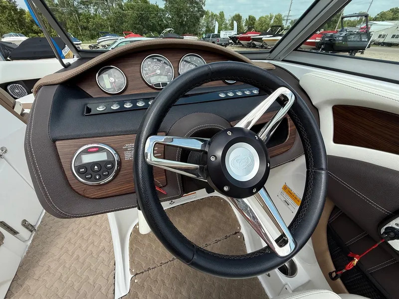 Slide: The Image of Steering wheel and dashboard of a 2014 Cobalt 24SD boat, featuring gauges and controls. - 20