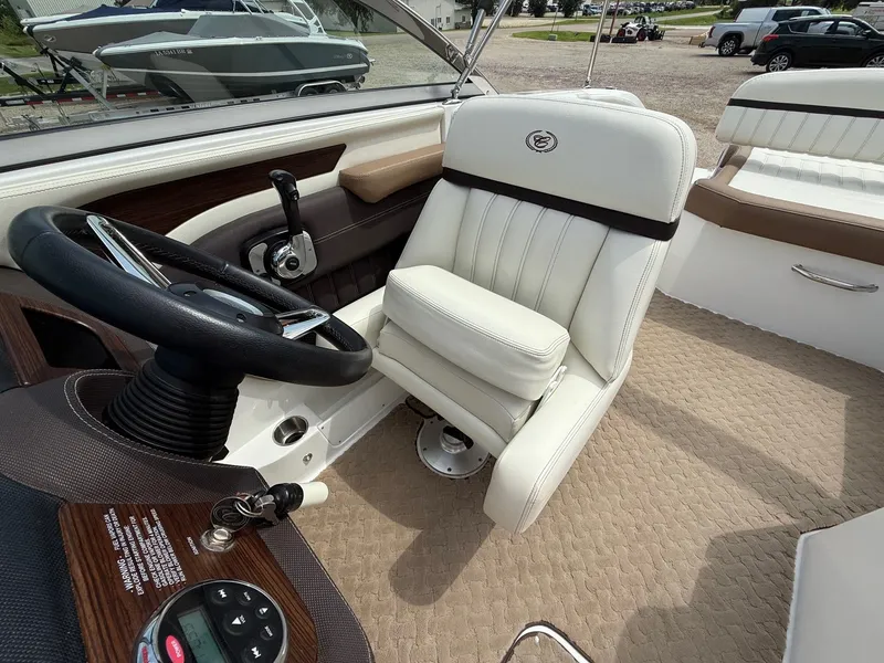 Slide: The Image of 2014 Cobalt 24SD boat interior with white captain's chair and steering wheel. - 24