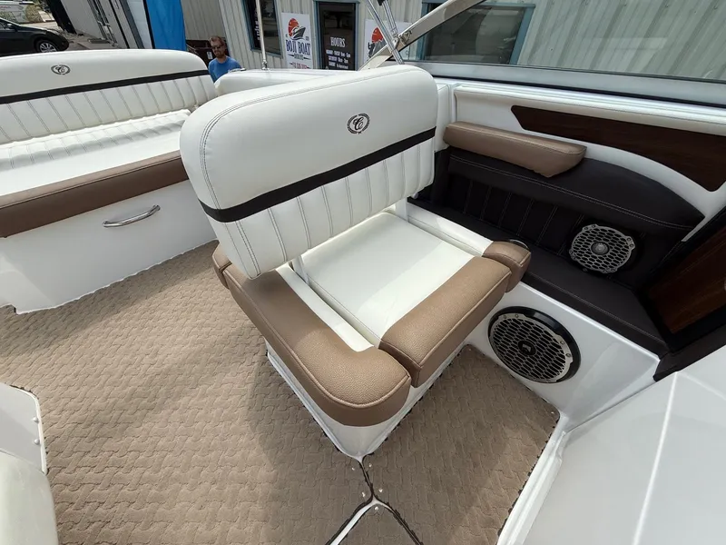 Slide: The Image of 2014 Cobalt 24SD boat interior with beige and white seating, featuring built-in speakers. - 25