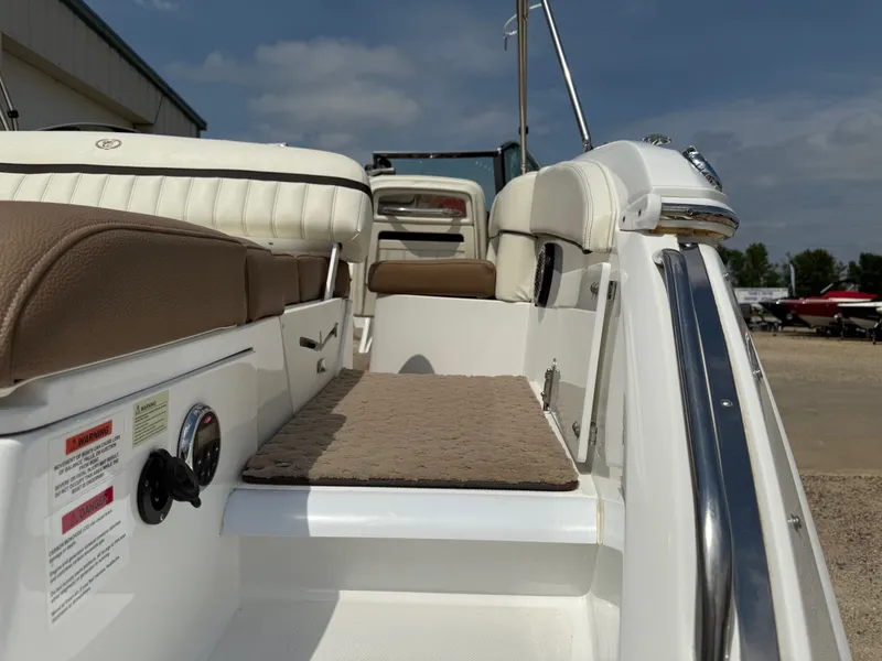Slide: The Image of 2014 Cobalt 24SD boat interior with cushioned seating and step, under a clear sky. - 30