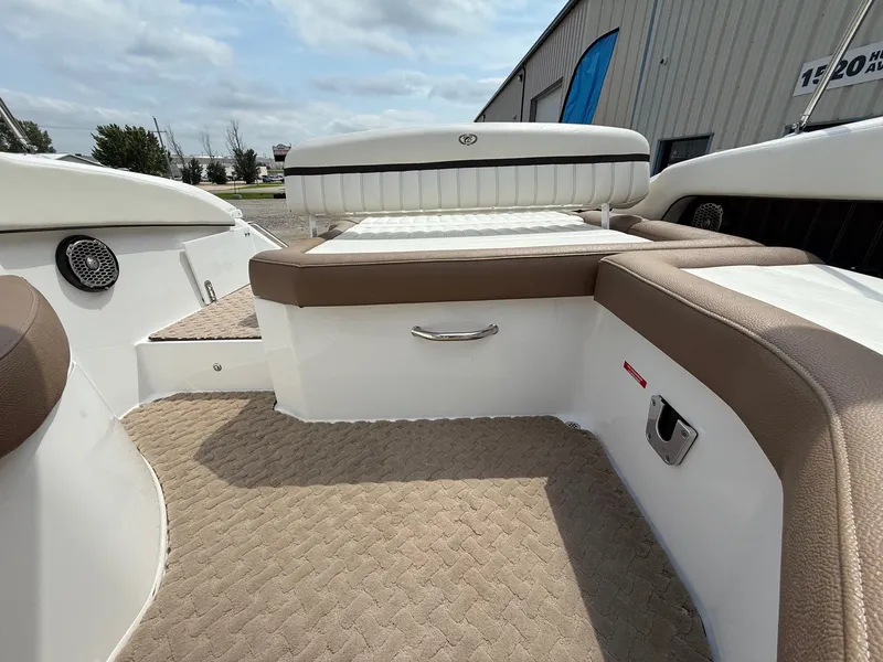 Slide: The Image of 2014 Cobalt 24SD boat interior with beige seating and carpet, docked outdoors. - 37