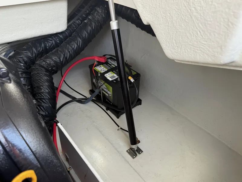 Slide: The Image of Battery compartment of a 2014 Cobalt 24SD boat with wiring and support strut. - 39