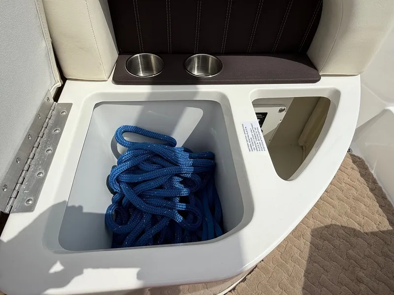 Slide: The Image of 2014 Cobalt 24SD boat storage with blue rope and cup holders. - 42