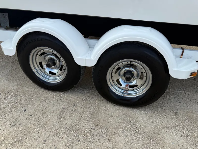 Slide: The Image of Dual trailer wheels with white fenders on a 2014 Cobalt 24SD boat trailer. - 43