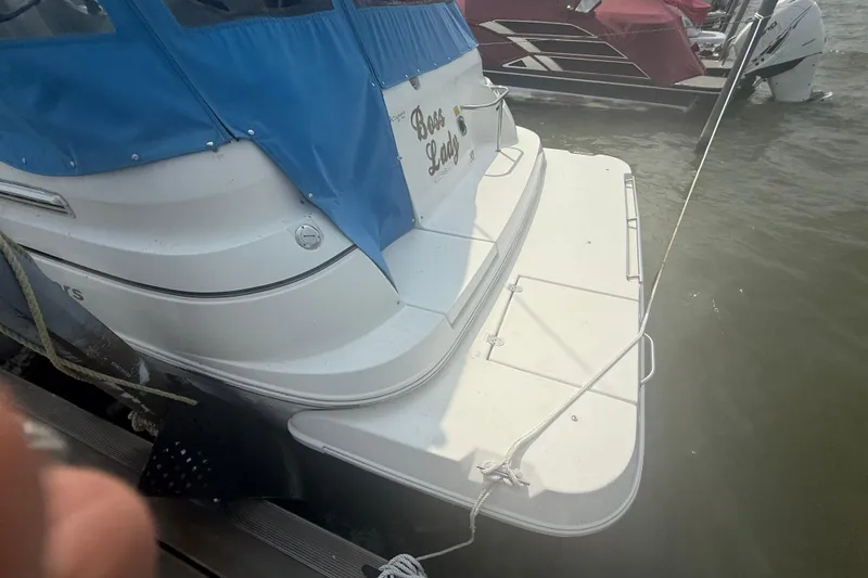 Slide: The Image of 2001 Cruisers Yachts 2870 Express docked with blue cover, rear view. - 15