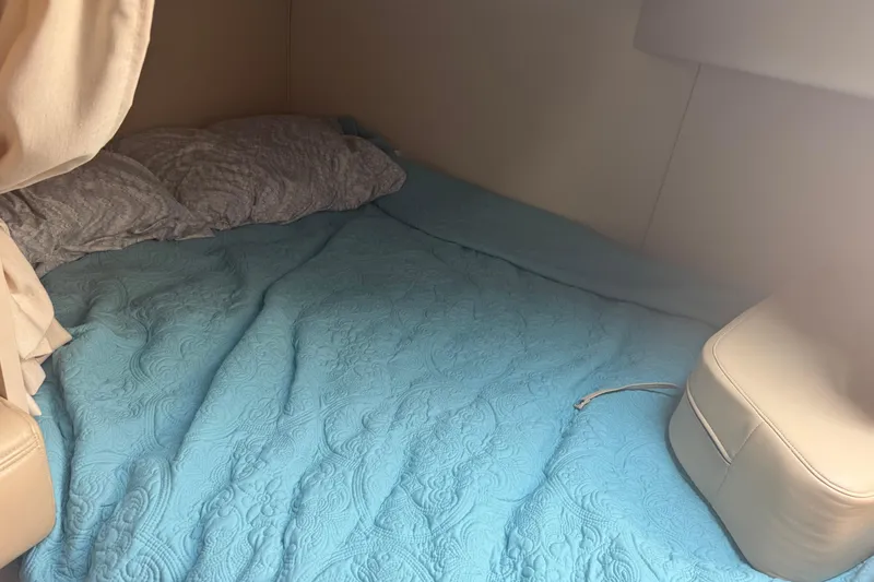 Slide: The Image of Cozy cabin bed with blue quilt in 2001 Cruisers Yachts 2870 Express. - 7