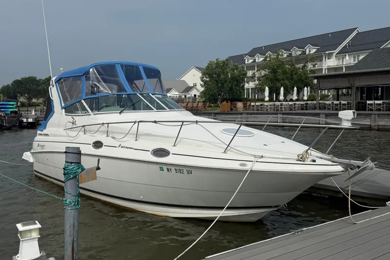 The Image of 2001 Cruisers Yachts 2870 Express docked at a marina with blue canopy. - 0