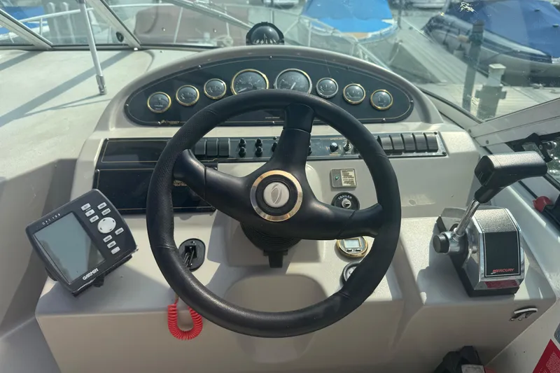 Slide: The Image of 2001 Cruisers Yachts 2870 Express helm with steering wheel, gauges, and controls. - 2