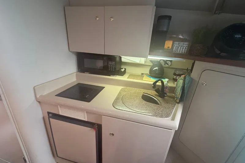 Slide: The Image of 2001 Cruisers Yachts 2870 Express galley with sink, stove, and microwave. - 6