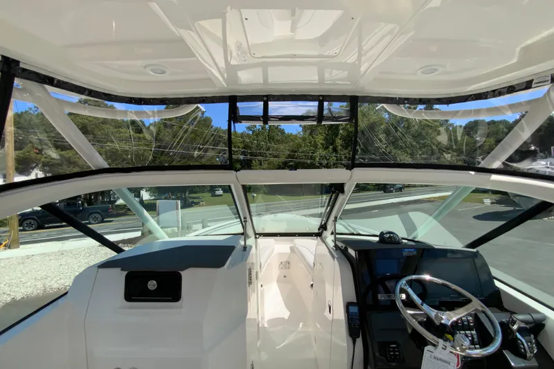Slide: The Image of 2026 Pursuit DC 266 Dual Console boat interior with steering wheel and dashboard view. - 14