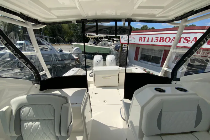 Slide: The Image of 2026 Pursuit DC 266 Dual Console boat interior with seating and cup holders. - 15