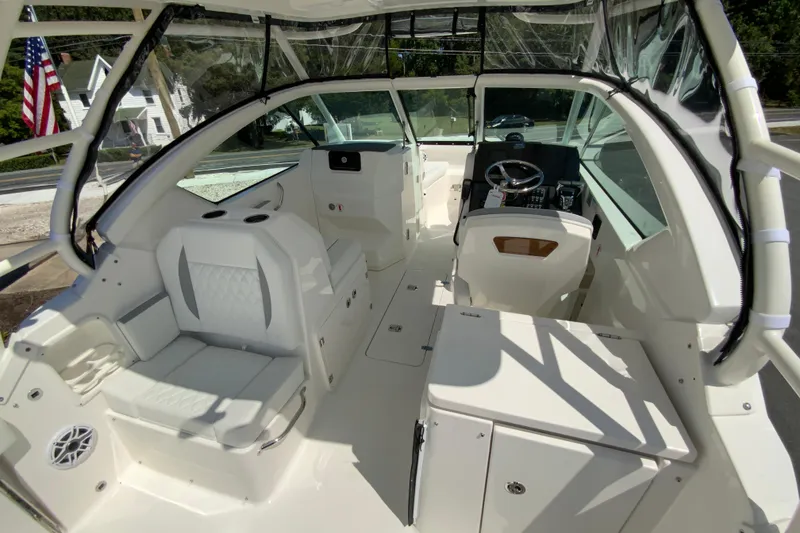 Slide: The Image of 2026 Pursuit DC 266 Dual Console boat interior with seating and steering wheel. - 17